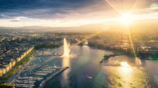 aerial view of Geneva city at sunset high angle view of Geneva city panoramic from drone point at sunset with famous travel destination jet d'eau and Geneva Lake. geneva switzerland photos stock pictures, royalty-free photos & images