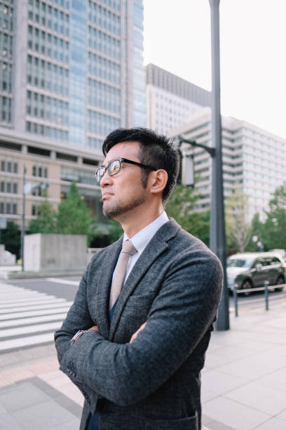 Businessman waiting in front of zebra crossing