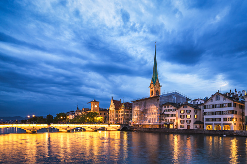View over the Limmat River and the old town of Zurich with the landmark Fraumünster church at dusk.