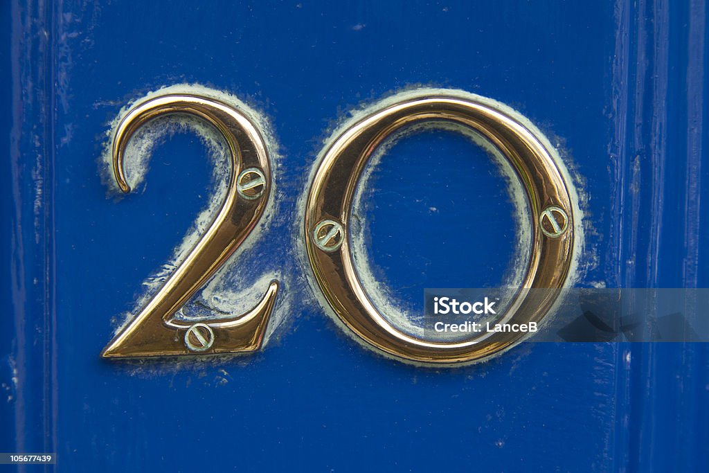 Twenty Weathered number 20 on painted blue door Door Stock Photo