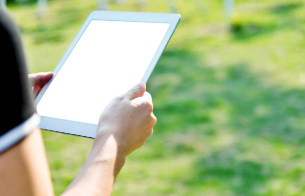 istock Woman hand using a digital tablet outdoors 1056776810