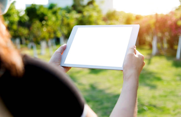 istock Woman hand using a digital tablet outdoors 1056778740
