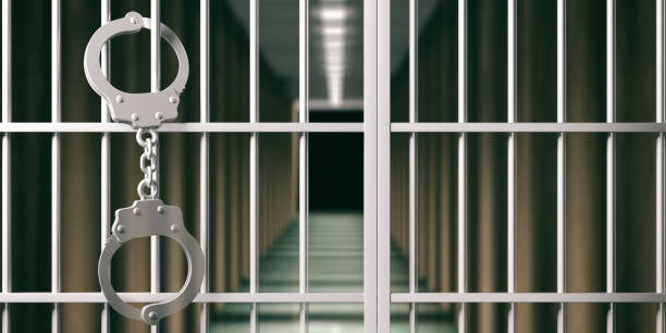 istock Prison concept. Jail bars and handcuffs, dark background. 3d illustration 1056779222