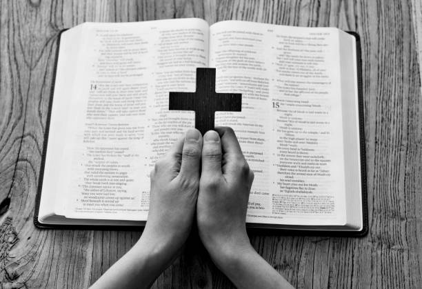 Woman hands praying with a cross.
