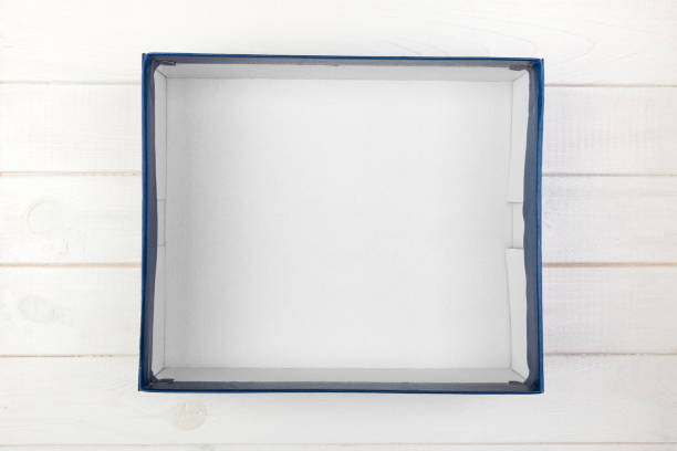 istock A empty blank white box on the desk top view on white wooden background 1056781766