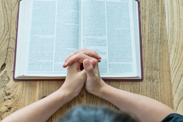 istock Woman praying on bible book 1056781822