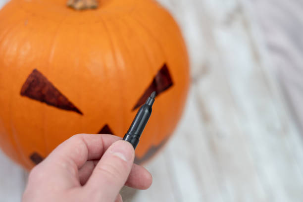 istock Drawing a pumpkin face for Halloween 1056785928