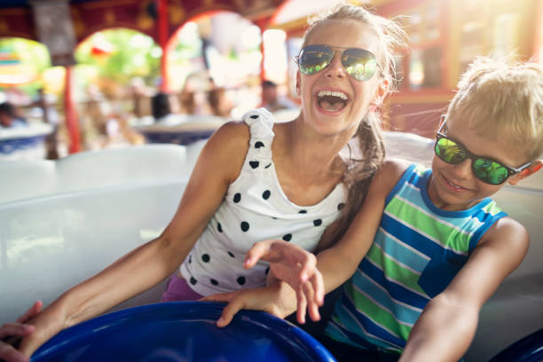 irmão e irmã, desfrutando de girar o carrossel - amusement park ride - fotografias e filmes do acervo