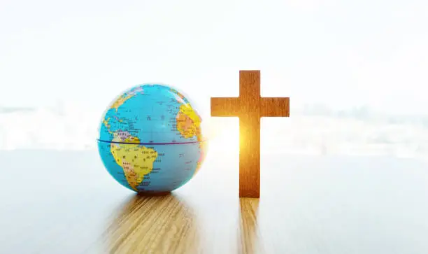 Photo of Earth globe and cross in table