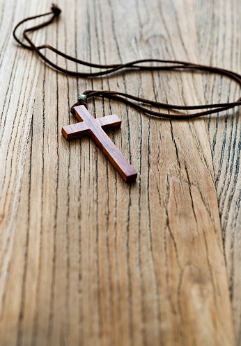 Wooden cross on desk background.