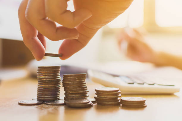 istock Hand putting coin stack step staircase on desk wit calculator. Save money and investment concept 1056791122