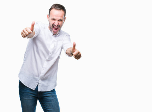 istock Middle age hoary senior man over isolated background approving doing positive gesture with hand, thumbs up smiling and happy for success. Looking at the camera, winner gesture. 1056796120