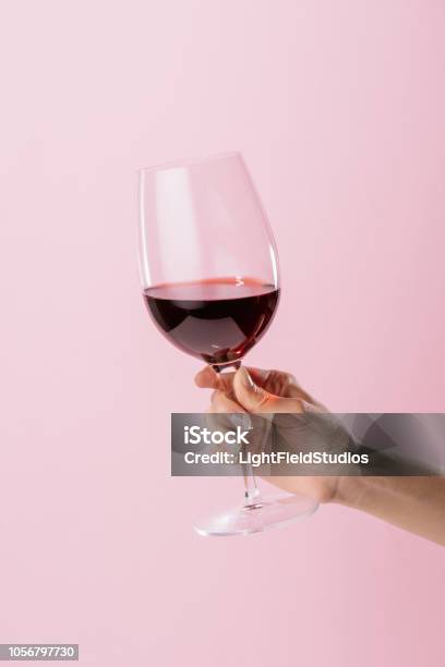 Foto de Tiro Recortado De Mulher Segurando O Copo De Vinho Tinto Isolado Em Rosa e mais fotos de stock de Vinho