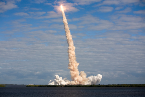 NASA Space Shuttle Atlantis moving through a cloud after launch