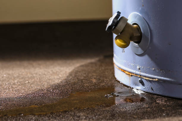 A leaking faucet on a domestic water heater Water leaking from the plastic faucet on a residential electric water heater sitting on a concrete floor. boiler photos stock pictures, royalty-free photos & images