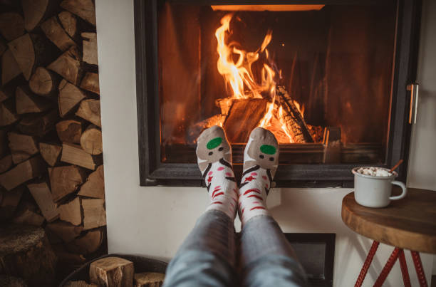 Best way to spend winter day Feet in wool socks near fireplace heat home interior comfortable human foot stock pictures, royalty-free photos & images