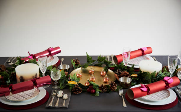 istock Decorated Christmas table set for four people, with Christmas crackers arranged on plates 1056806060
