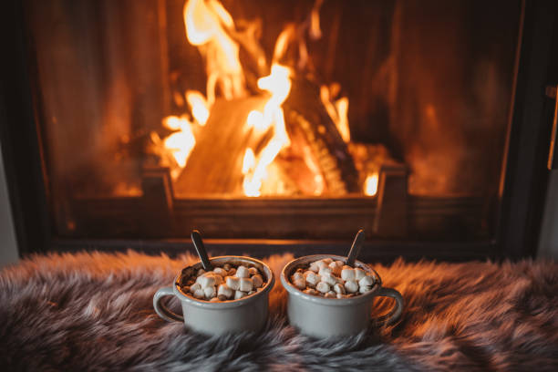 Cozy winter drink Cups with hot chocolate on fur, fireplace in background cosy stock pictures, royalty-free photos & images