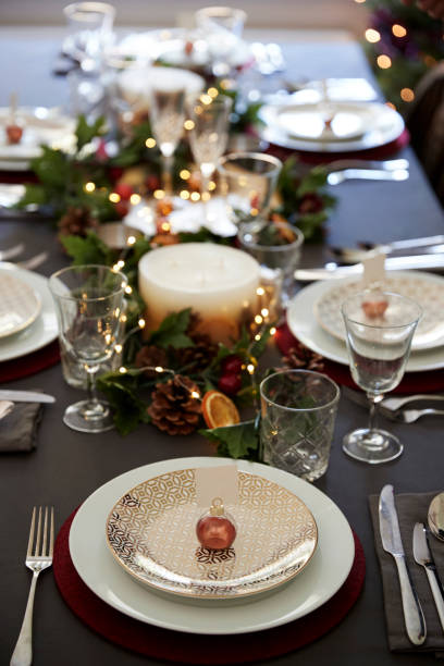 istock Christmas table setting with bauble name card holder arranged on a plate and green and red decorations, elevated view 1056806464