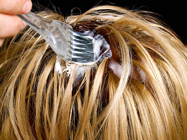 Woman getting roots of hair dyed Closeup view during  hair dyeing  treatment ... colouring stock pictures, royalty-free photos & images