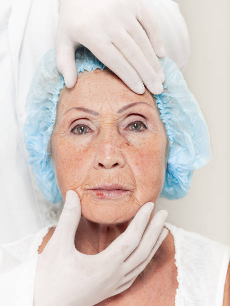 istock surgeon doing skin check on mid age woman before plastic surgery 1056811036