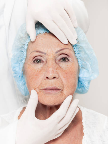 istock surgeon doing skin check on mid age woman before plastic surgery 1056811046