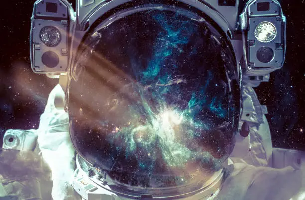 Photo of Dark nebula and stars in space, reflection on the spacesuit helmet. Adventure of spaceman. Astronaut in outer space. Elements of this image furnished by NASA.