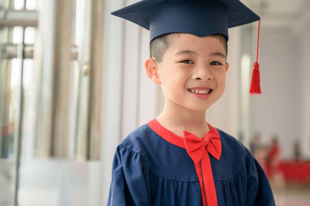 Young asian boy in graduation gown