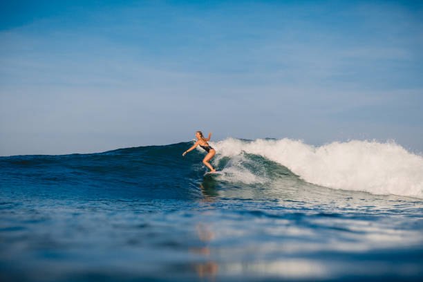 istock Young surfer girl ride on perfect ocean wave. 1056825908