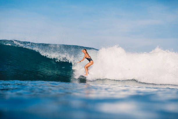 istock Young surfer girl and perfect ocean wave. 1056825932