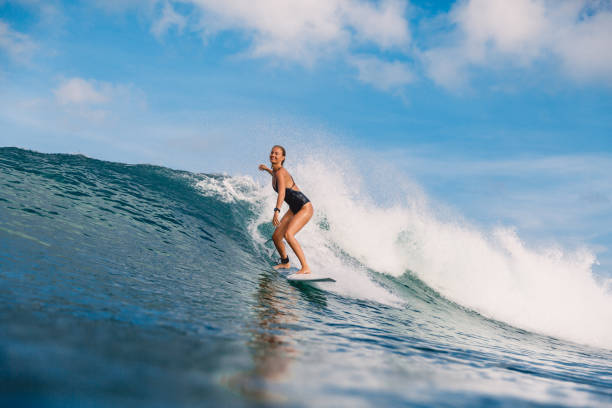 istock Surfer girl on blue wave. Woman during surfing 1056826036