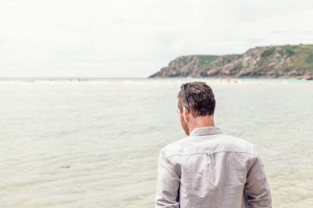 istock Man looking out over the water at Pedn Vounder Beach, Cornwall 1056830440