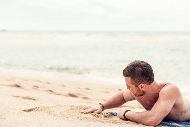 istock Man sunbathing on Pedn Vounder Beach, Cornwall on a sunny June day. 1056830452