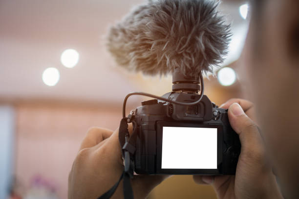 istock Video or professional digital mirrorless on tripod for camera recording with microphone taking photograp in wedding convention hall in live streaming event, seminar production equipment. 1056832582