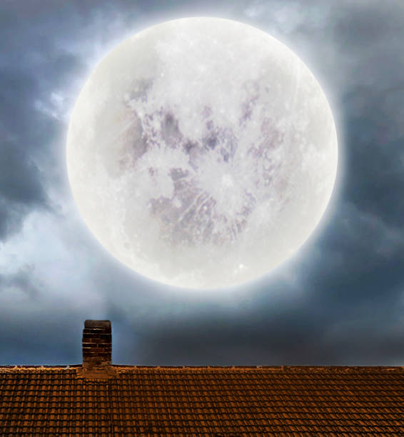 istock Full Moon up in the sky above roof 1056832708