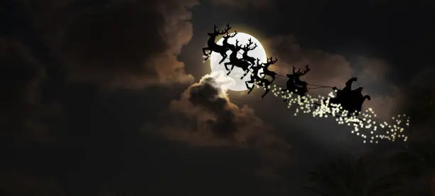 Photo of Santa riding sleigh with reindeers silhouette