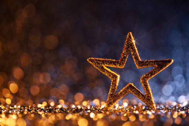 Decorative christmas still life. Christmas star on gold and blue glitter background.
