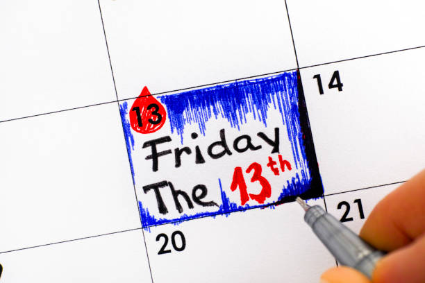 Woman fingers with pen writing reminder Friday The 13th in calendar. Woman fingers with pen writing reminder Friday The 13th in calendar. Close-up. friday the 13th stock pictures, royalty-free photos & images