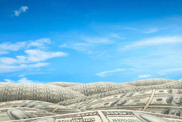 istock American dollar bills covered rolling landscape over blue sky 1056838344