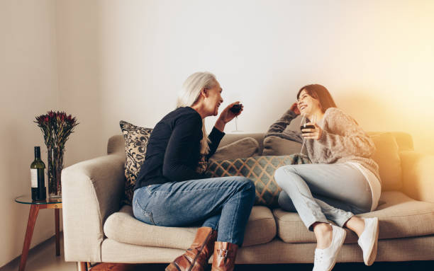 istock Two women sitting on couch at home talking 1056840784