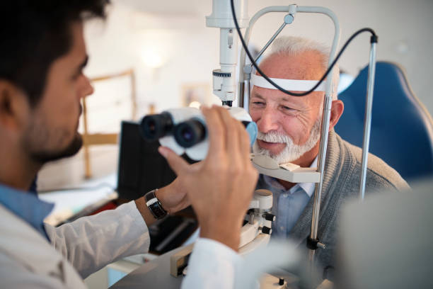 homens velhos tendo um exame no consultório do oftalmologista. - eye exam senior adult medical equipment men - fotografias e filmes do acervo