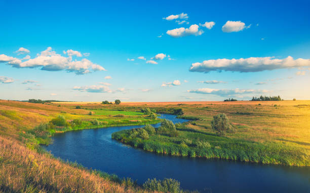 istock Sunny summer landscape with fields,river bend and beautiful woods. 1056843884