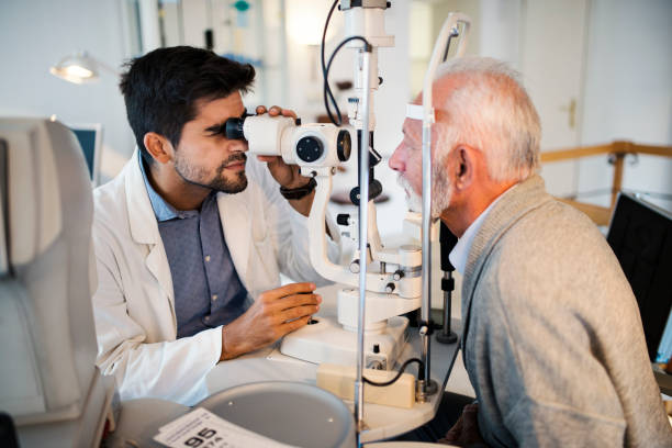 vecchi che hanno un esame oculistico nell'ufficio dell'oftalmologo. - optometrie foto e immagini stock