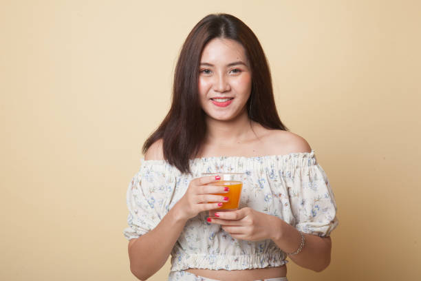 istock Young Asian woman drink orange juice. 1056847116