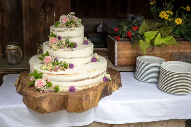White Wedding Cake with pink Roses and Flowers on a cut Tree