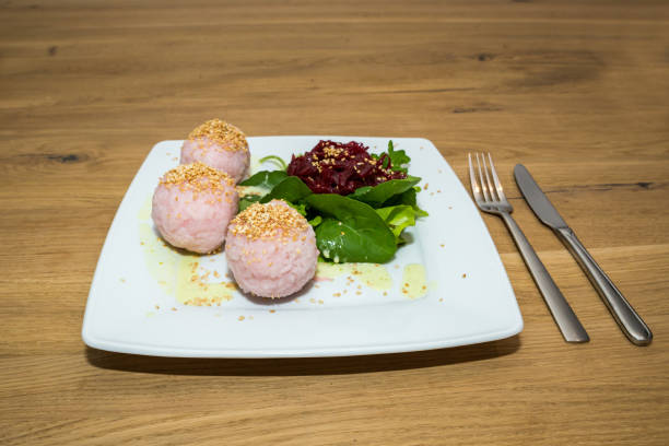istock Salad with Beet and Sushi Balls on white Plate on wooden Table 1056849498