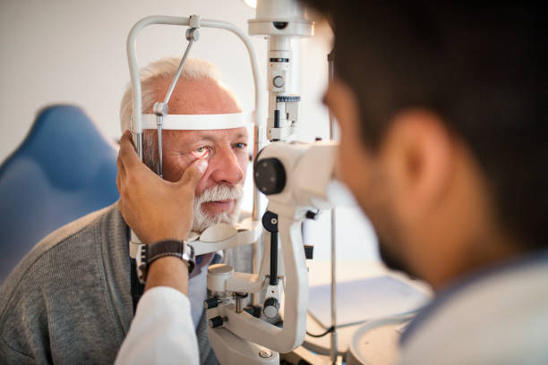 homens velhos tendo um exame no consultório do oftalmologista. - eye exam senior adult medical equipment men - fotografias e filmes do acervo