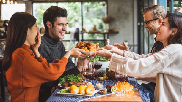 素晴らしく��グラスワインとクリスマス パーティー ディナーを祝っている若い人たちのグループ - toast glass wine dinner ストックフォトと画像