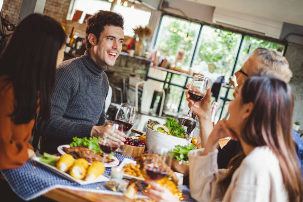 grupa młodych ludzi świętuje bożonarodzeniową kolację z kieliszkiem wina - buffet thai cuisine asian ethnicity food zdjęcia i obrazy z banku zdjęć