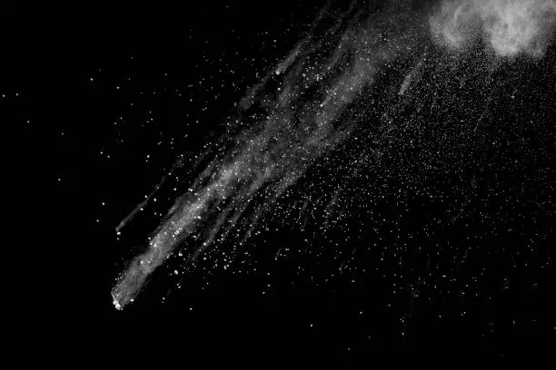 Photo of Explosion of white dust on black background.